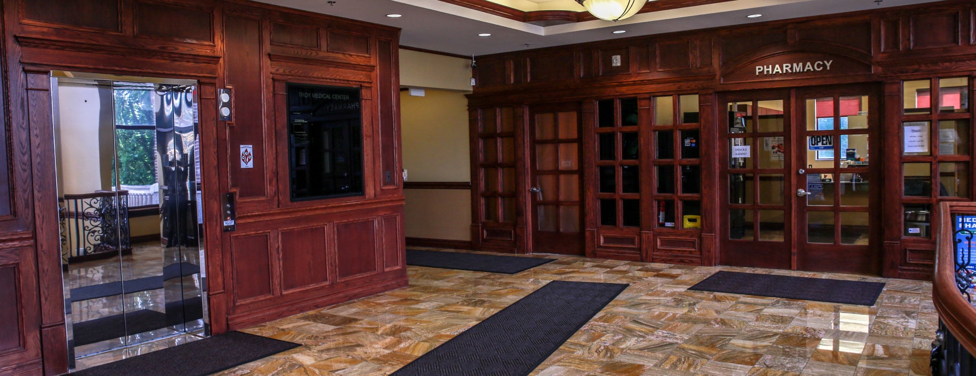 Shared building lobby outside the clinic, with an elevator and pharmacy entrance